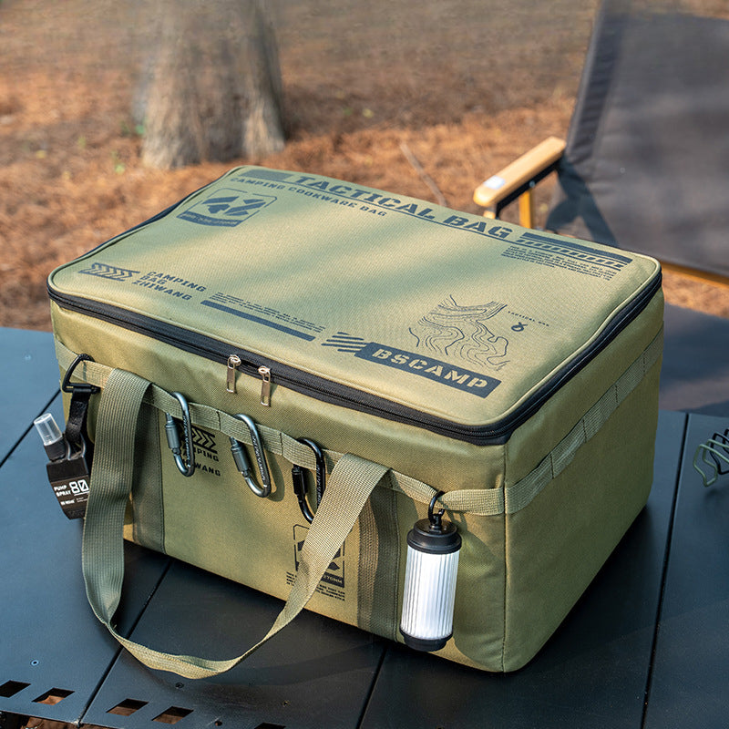 Olive green BSCAMP tactical camping cookware bag with carabiners and lantern on outdoor table.
