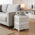 White rolling storage cart used as a side table beside a sofa, topped with a succulent, glasses, and magazines in a cozy living room.
